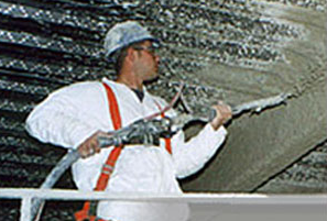 Worker spraying grace fire proofing onto a ceiling